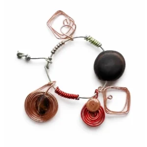 Abstract handcrafted wire jewelry piece featuring copper geometric spirals, metallic beads, and contemporary artistic elements arranged in a circular composition on a clean white background, created by Serj Éty’n.