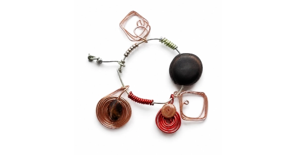 Abstract handcrafted wire jewelry piece featuring copper geometric spirals, metallic beads, and contemporary artistic elements arranged in a circular composition on a clean white background, created by Serj Éty’n.