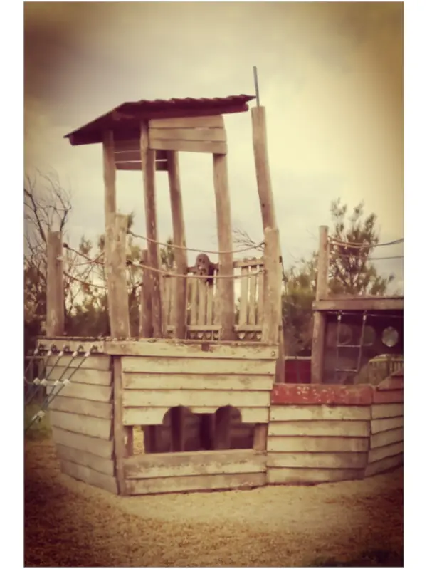 Vintage-style photograph of a weathered wooden playground structure resembling a ship, captured in soft sepia tones under a cloudy sky, with the title “One Way Ticket” displayed beneath the image.