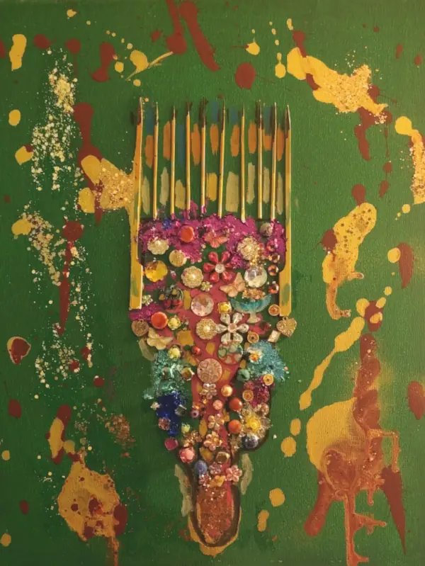Mixed-media artwork featuring an ornate Afro pick comb decorated with colorful jewels, beads, flowers, and metallic embellishments on a textured green background with gold and brown paint splashes. The comb resembles a ceremonial throne, symbolizing Afro beauty, elegance, and cultural pride. Created by Serj Éty’n.