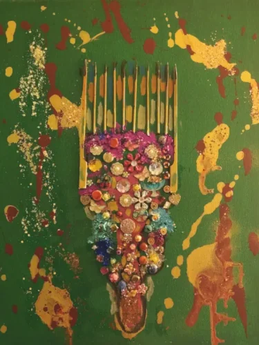 Mixed-media artwork featuring an ornate Afro pick comb decorated with colorful jewels, beads, flowers, and metallic embellishments on a textured green background with gold and brown paint splashes. The comb resembles a ceremonial throne, symbolizing Afro beauty, elegance, and cultural pride. Created by Serj Éty’n.